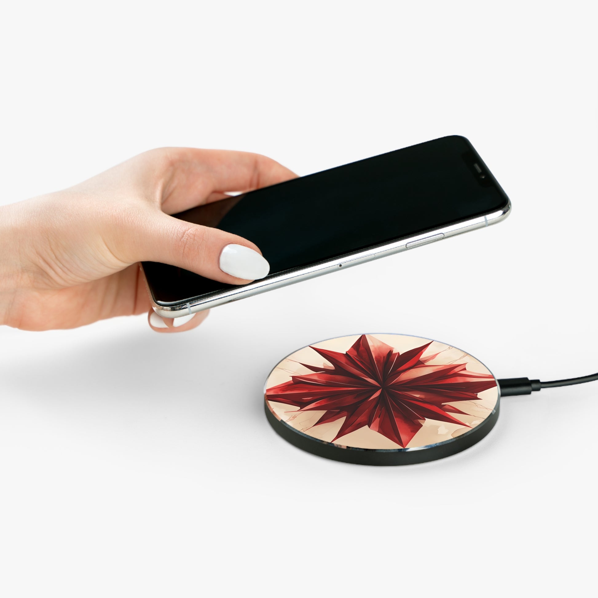Hand placing smartphone on Ruby Compass ruby red compass star design Qi wireless charger