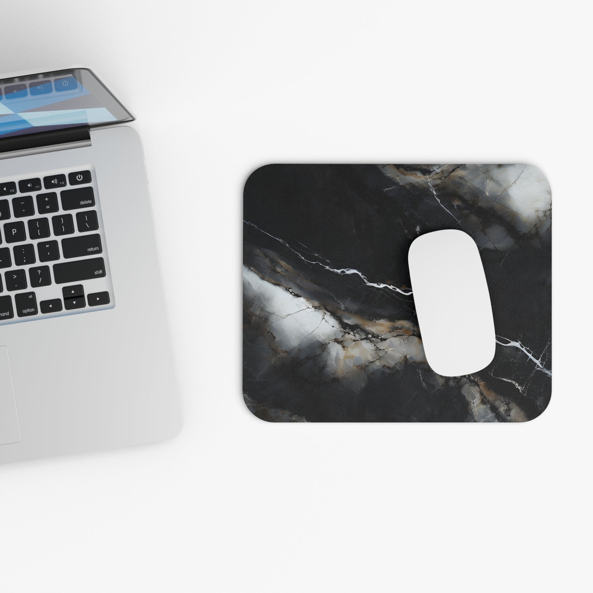 Obsidian Vein mouse pad beside laptop displaying black marble design