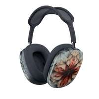 Ember Bloom AirPods Max cover with warm red and peach abstract flower on cool grey‑blue background, angled view on Apple AirPods Max headphones