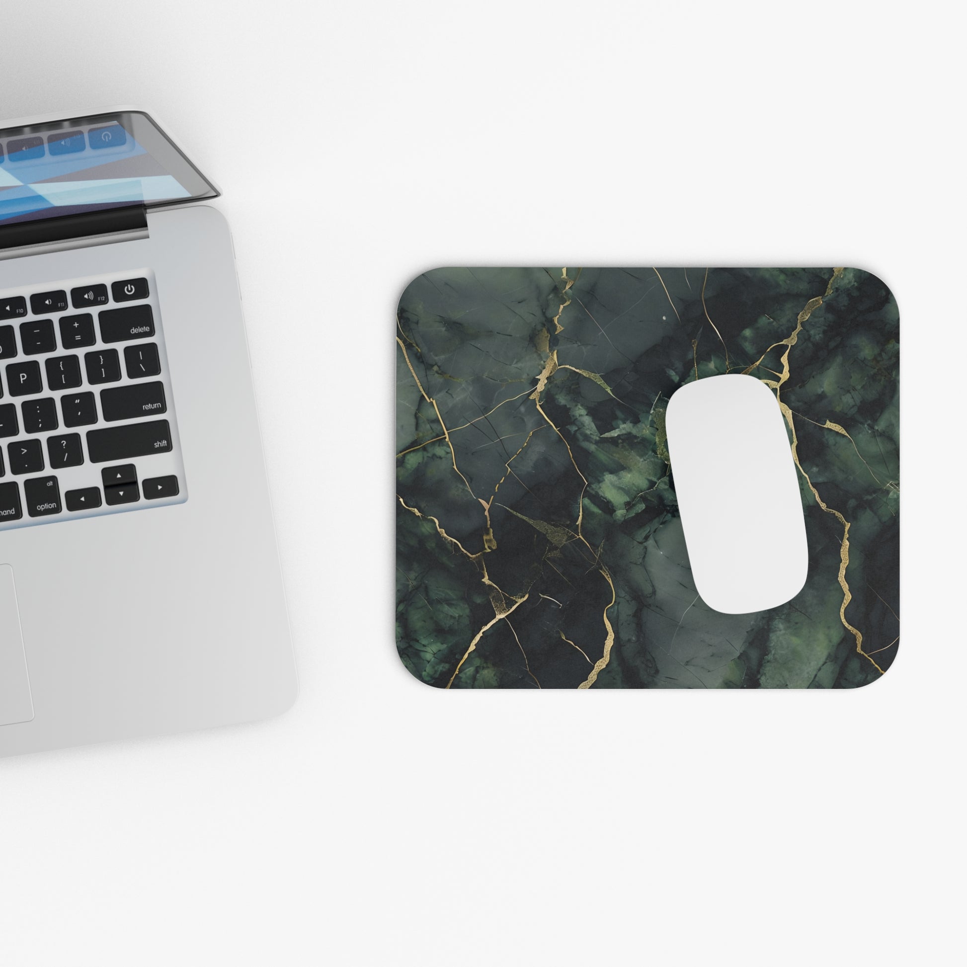 Verdant Vein mouse pad beside laptop displaying green marble design