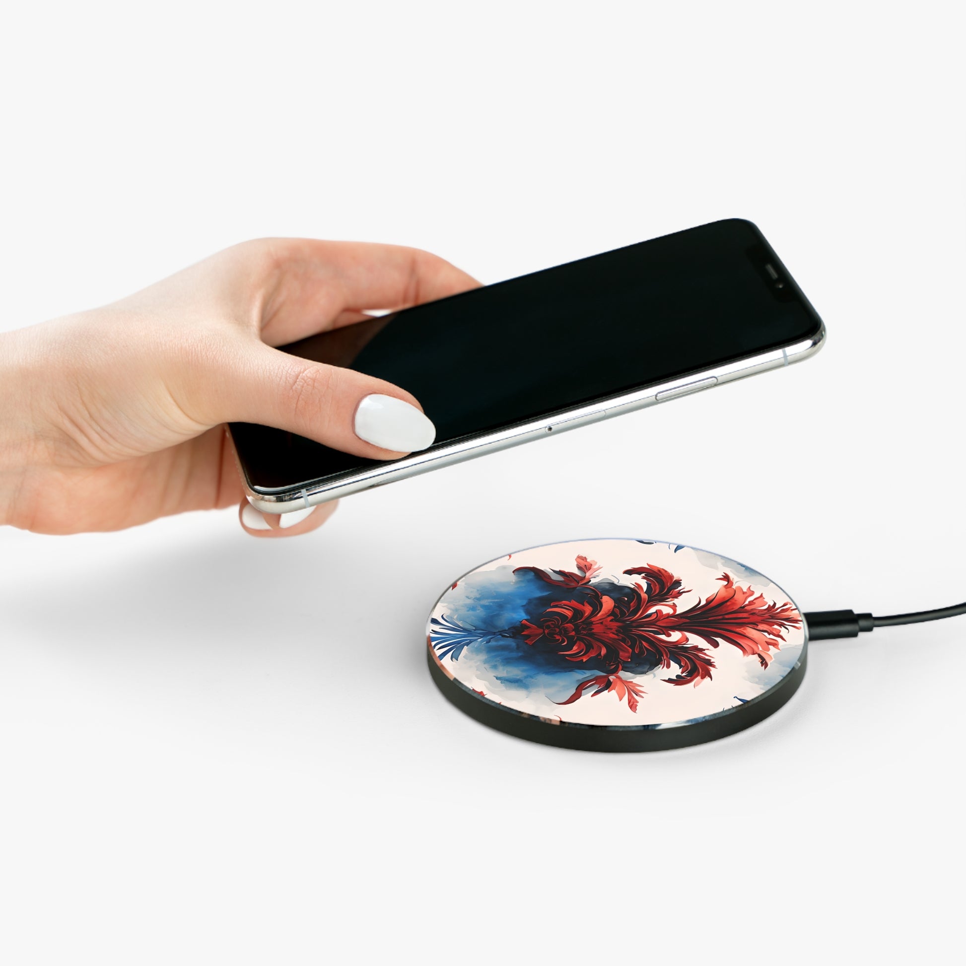 Hand placing smartphone on Crimson Plume red, white and blue floral design Qi wireless charger