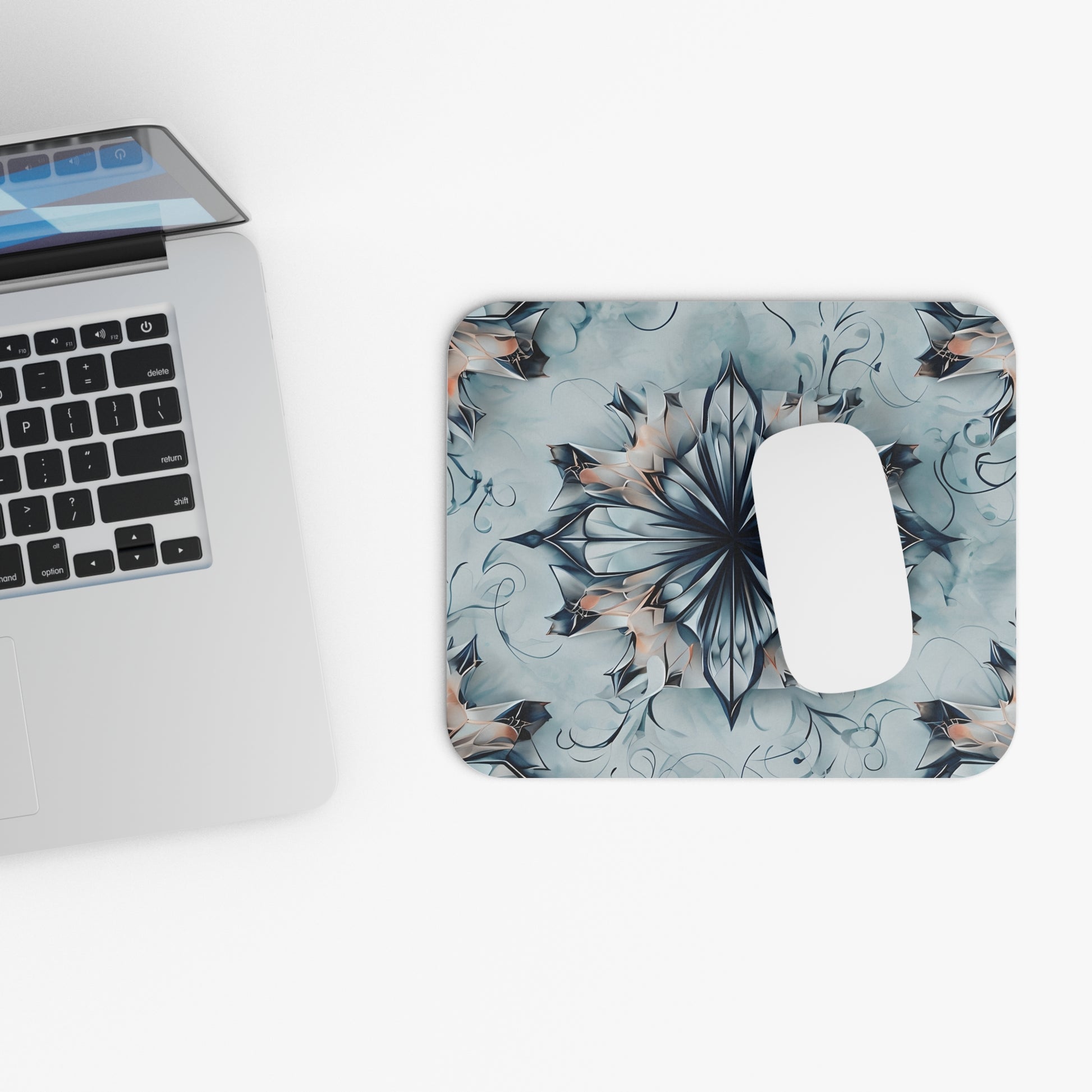 Indigo Mirage mouse pad beside laptop displaying blue abstract design