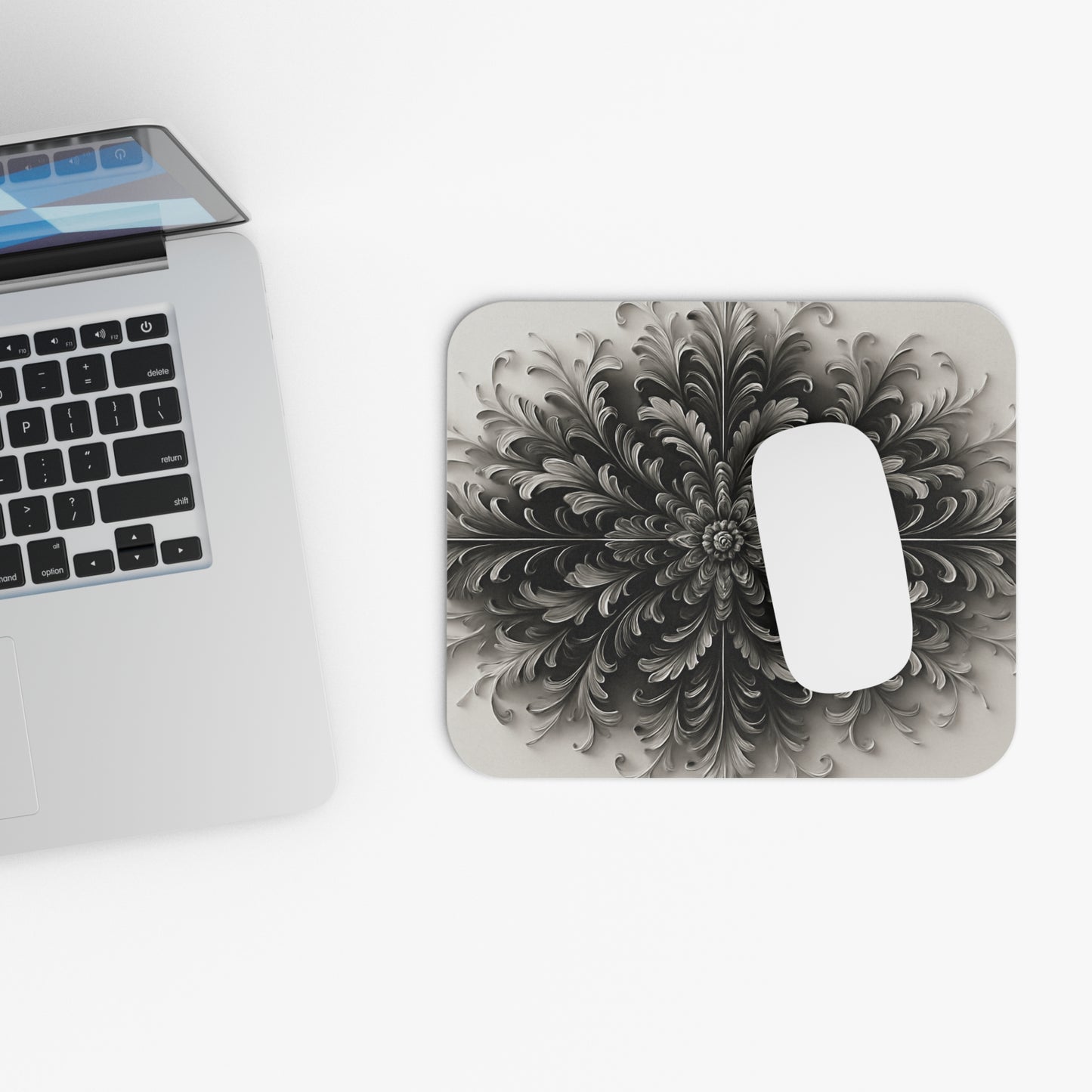Obsidian Bloom mouse pad beside laptop displaying black floral bloom artwork