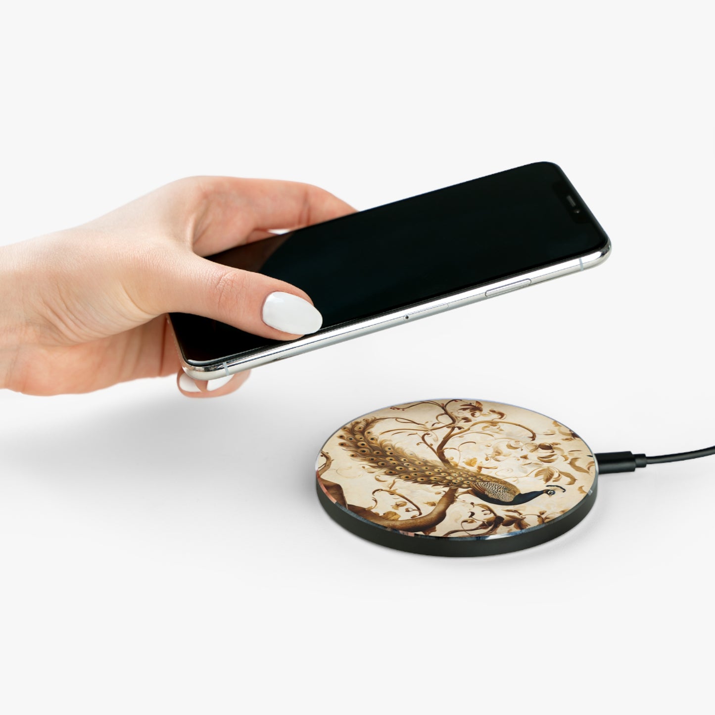 Hand placing smartphone on Golden Plumage gold peacock design Qi wireless charger