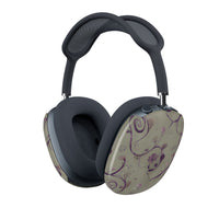 Twilight Thistle AirPods Max cover with delicate purple thistle vines on soft taupe background, angled view on Apple AirPods Max headphone