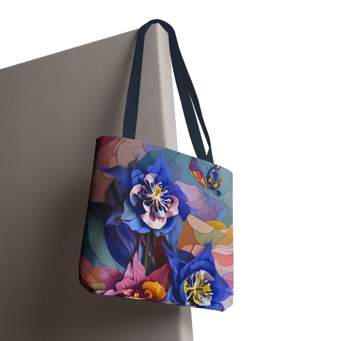 Blue Columbine Carnivale canvas tote bag hanging with vibrant blue floral carnivale artwork