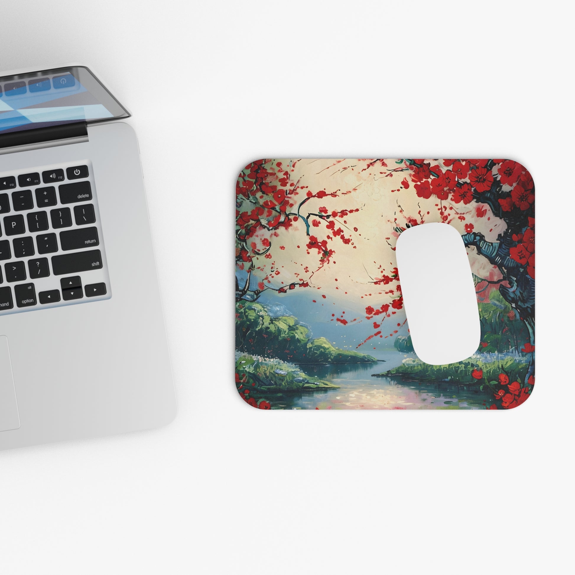 Crimson Blossom mouse pad beside laptop displaying red blossom design
