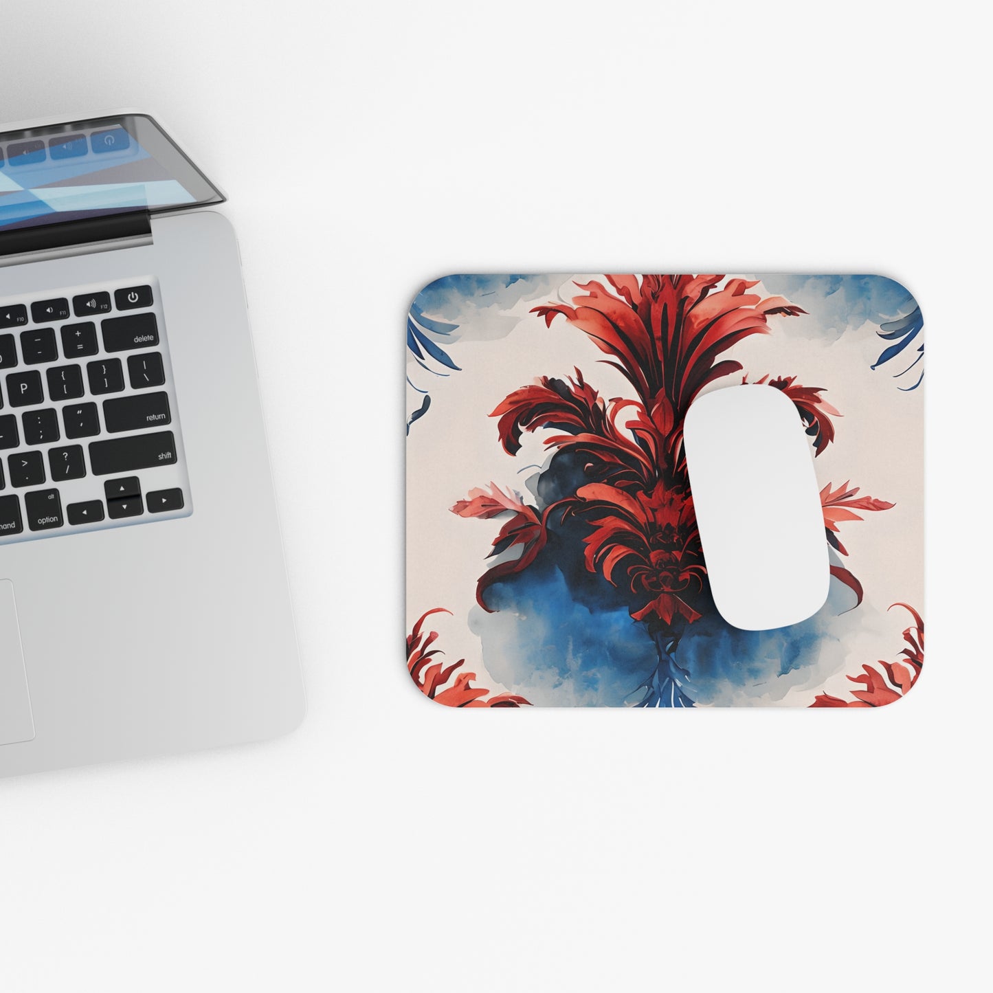 Crimson Plume mouse pad beside laptop displaying crimson plume design