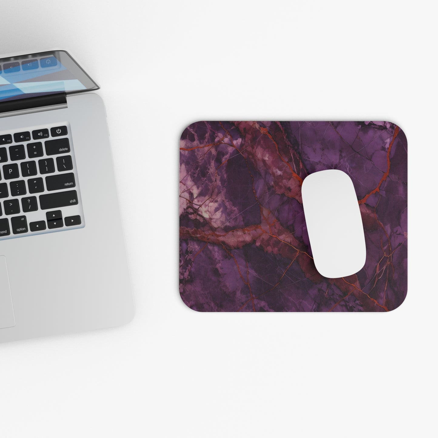 Amethyst Current mouse pad beside laptop displaying amethyst abstract design