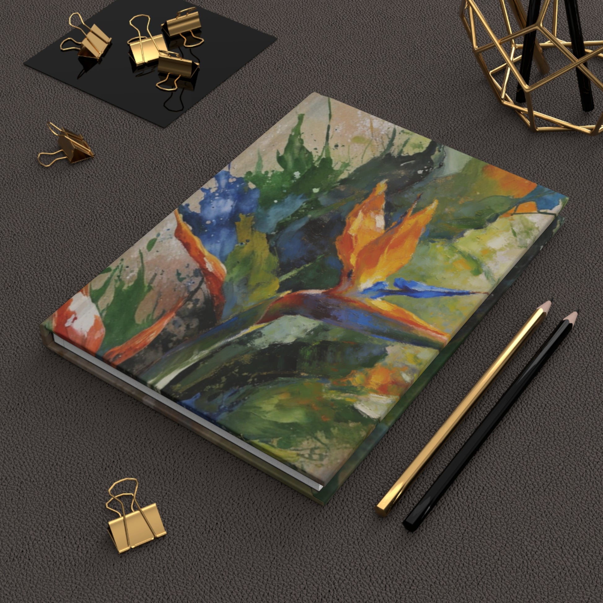 Solara Tropique hardcover journal on dark desk styled with pen, clips, and gold accessories, flatlay of tropical notebook