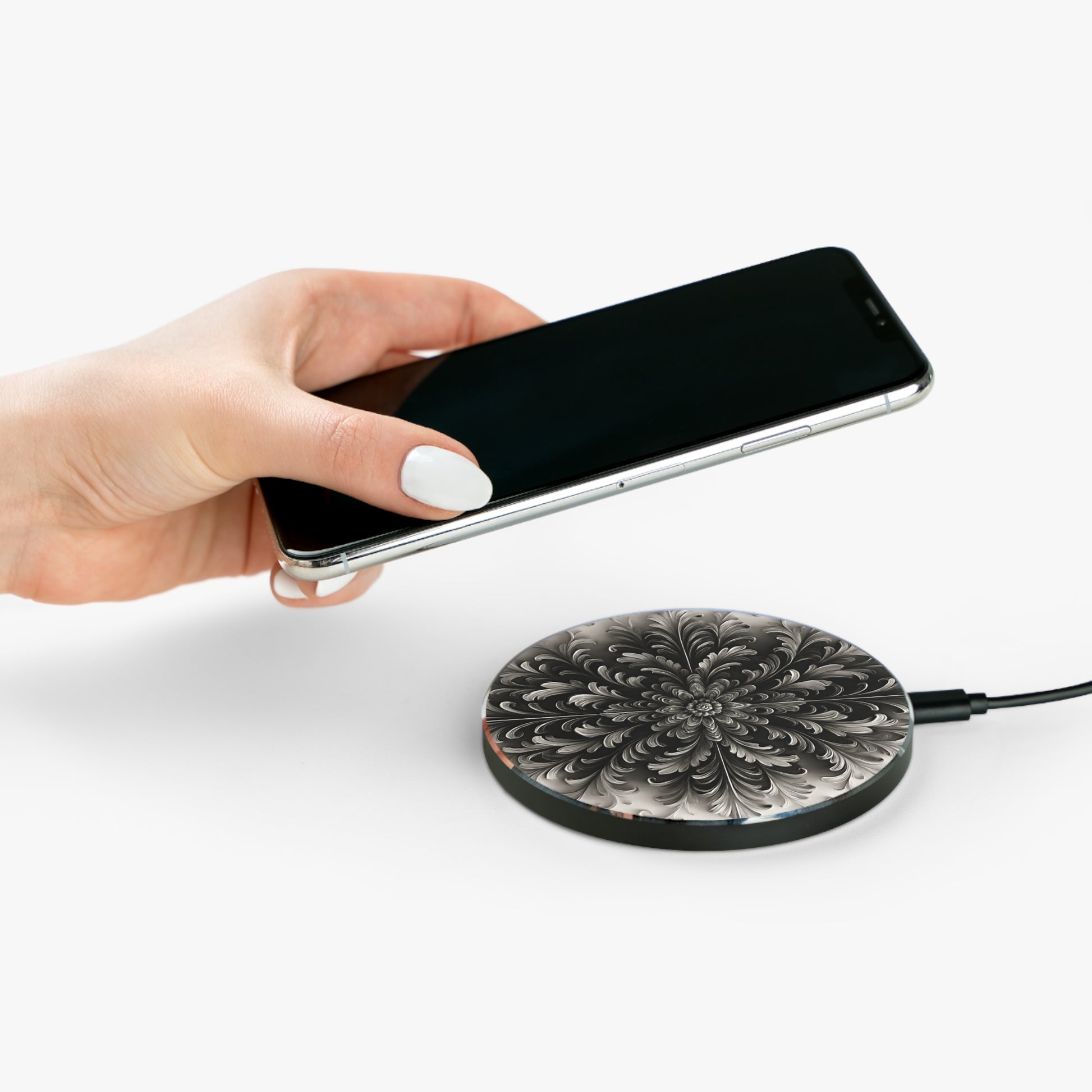 Hand placing smartphone on Obsidian Bloom black floral mandala design Qi wireless charger