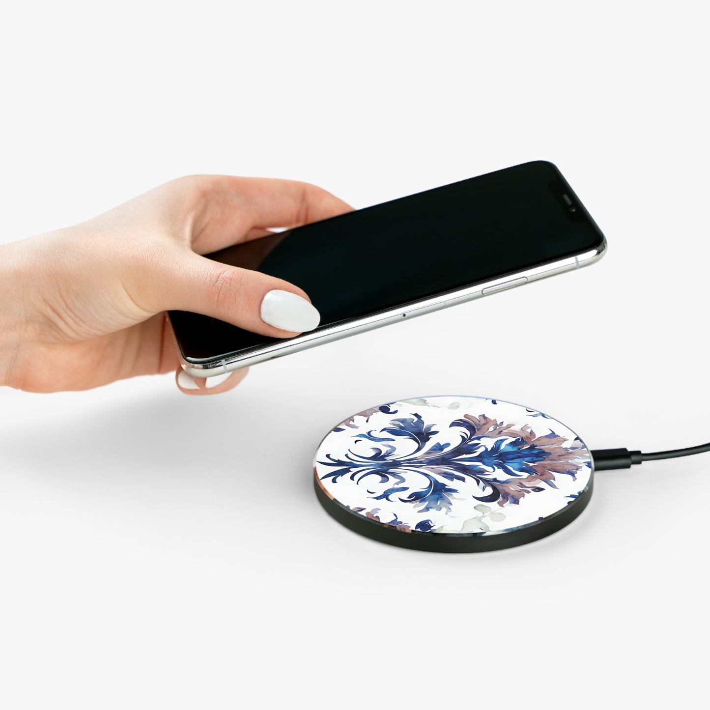 Hand placing smartphone on Delft Reverie blue Delft floral design Qi wireless charger
