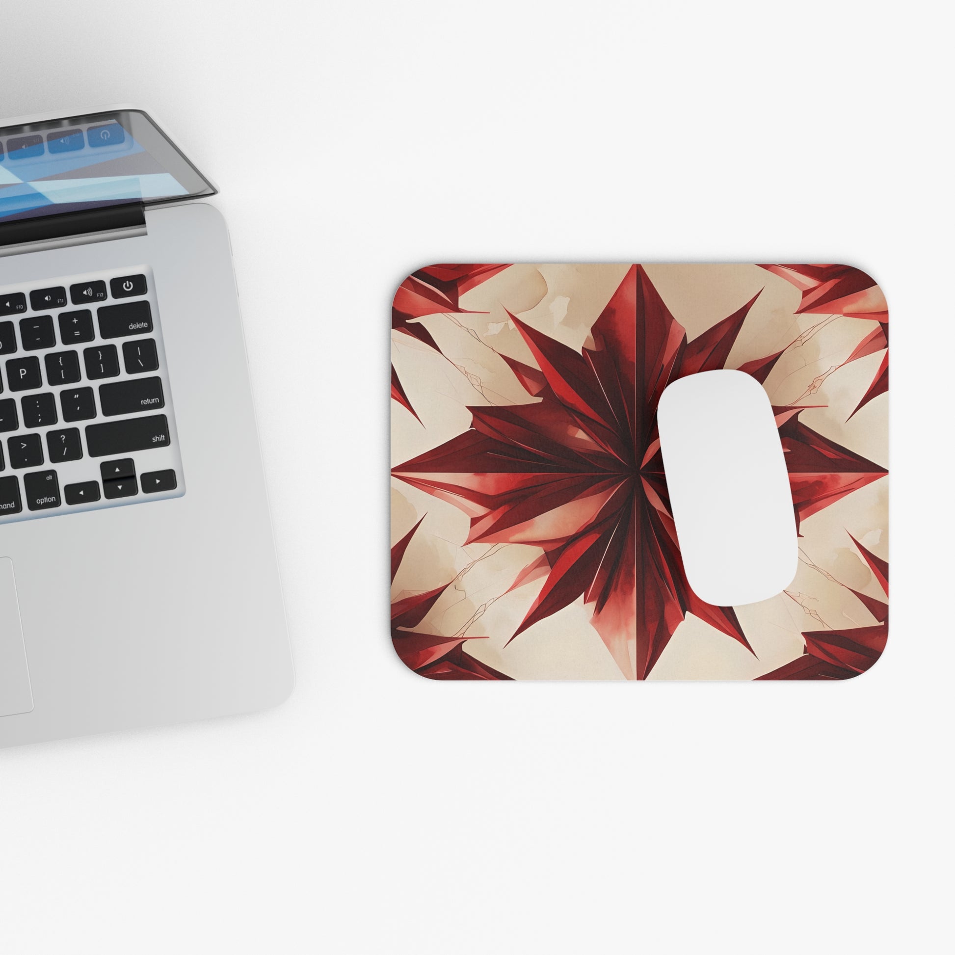 Ruby Compass mouse pad beside laptop displaying red geometric compass design