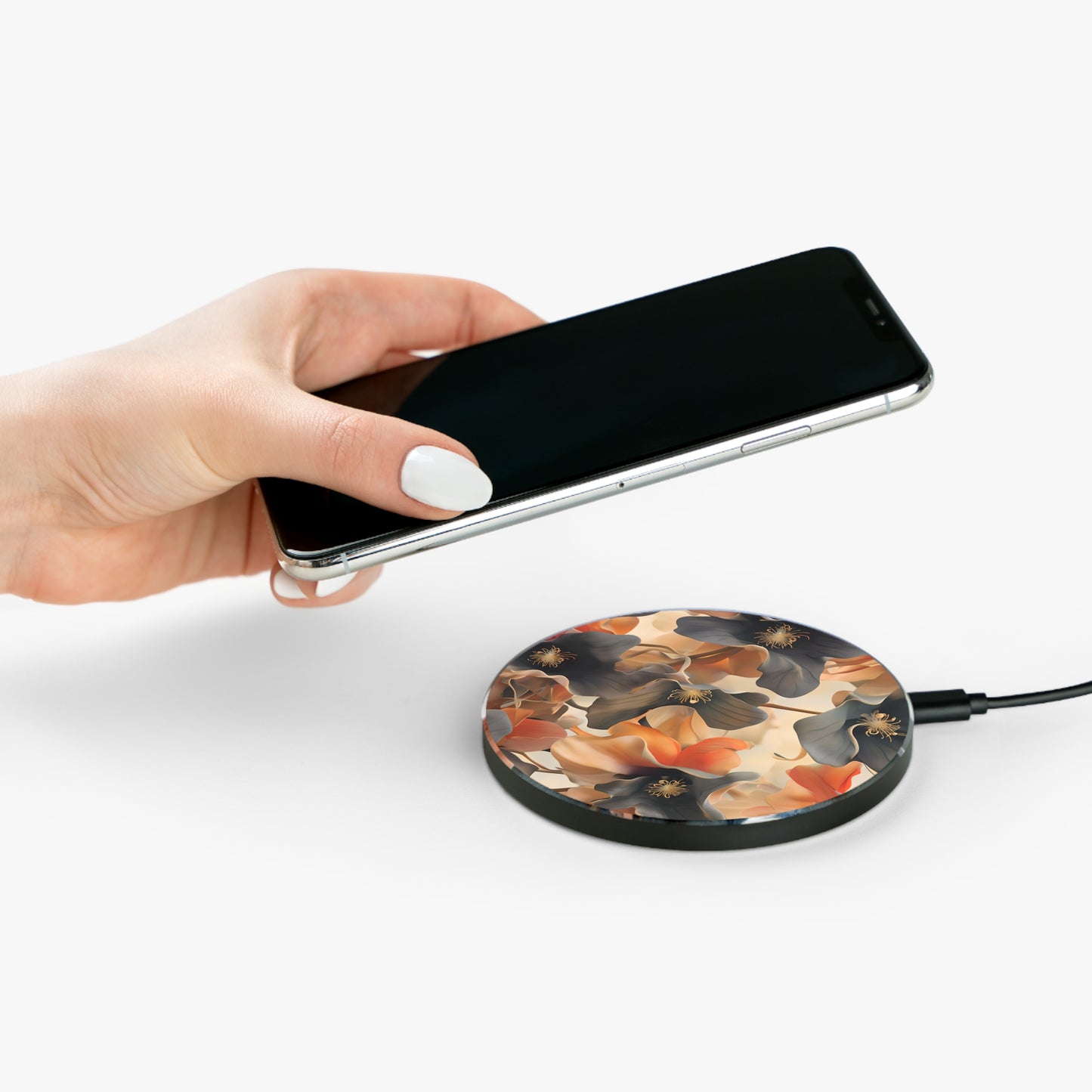 Hand placing smartphone on Autumn Ember fall floral design Qi wireless charger