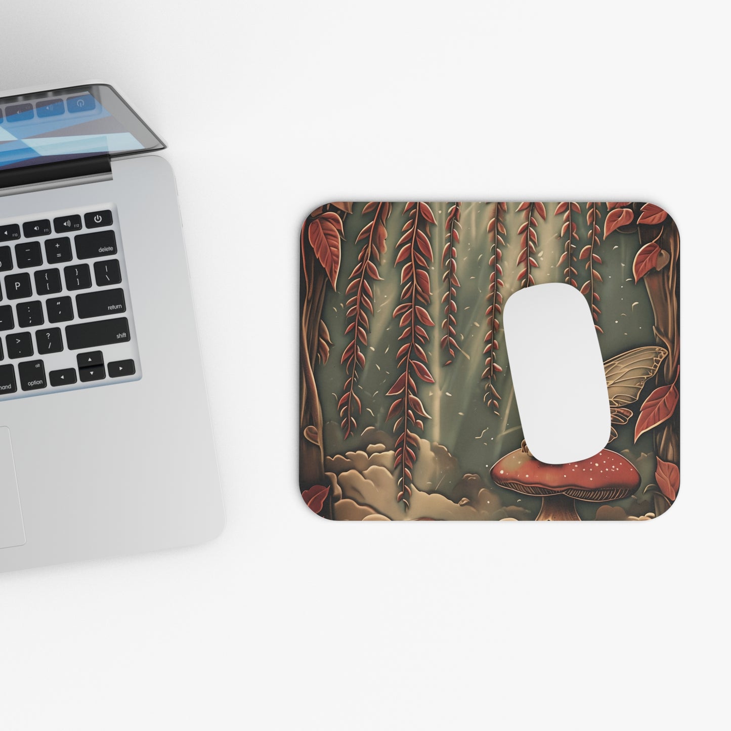 Willow Whisper mouse pad beside laptop displaying woodland botanical artwork