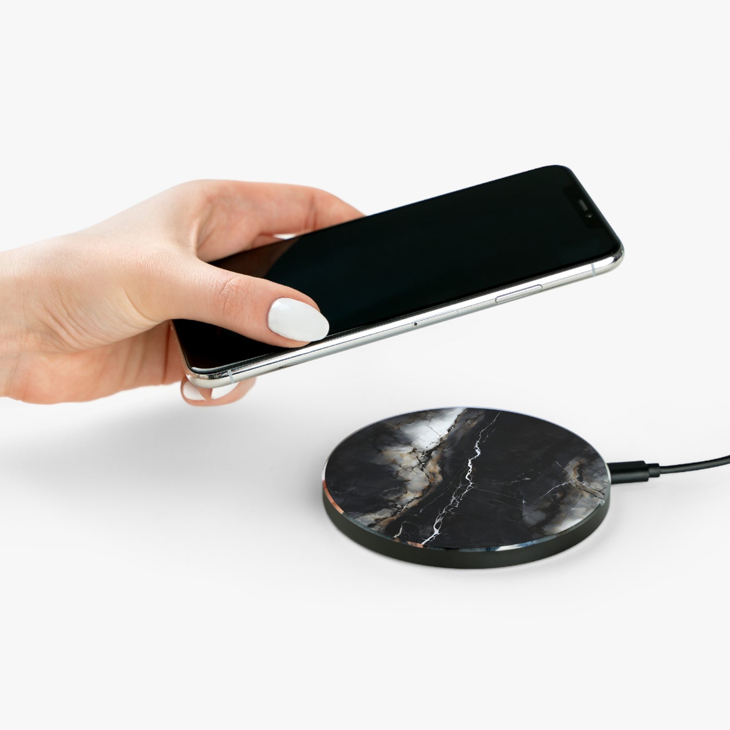 Hand placing smartphone on Obsidian Vein black marble vein design Qi wireless charger