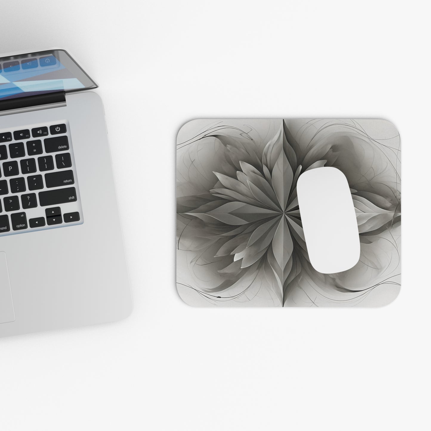 Silver Lotus mouse pad beside laptop displaying gray lotus mandala design
