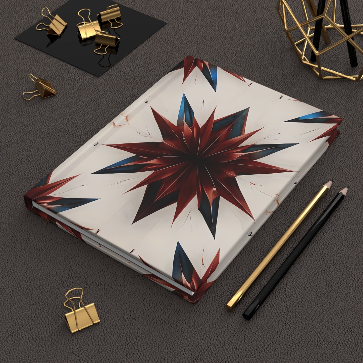 Garnet Starburst red white and blue 
hardcover journal on desk with pencils and stationery