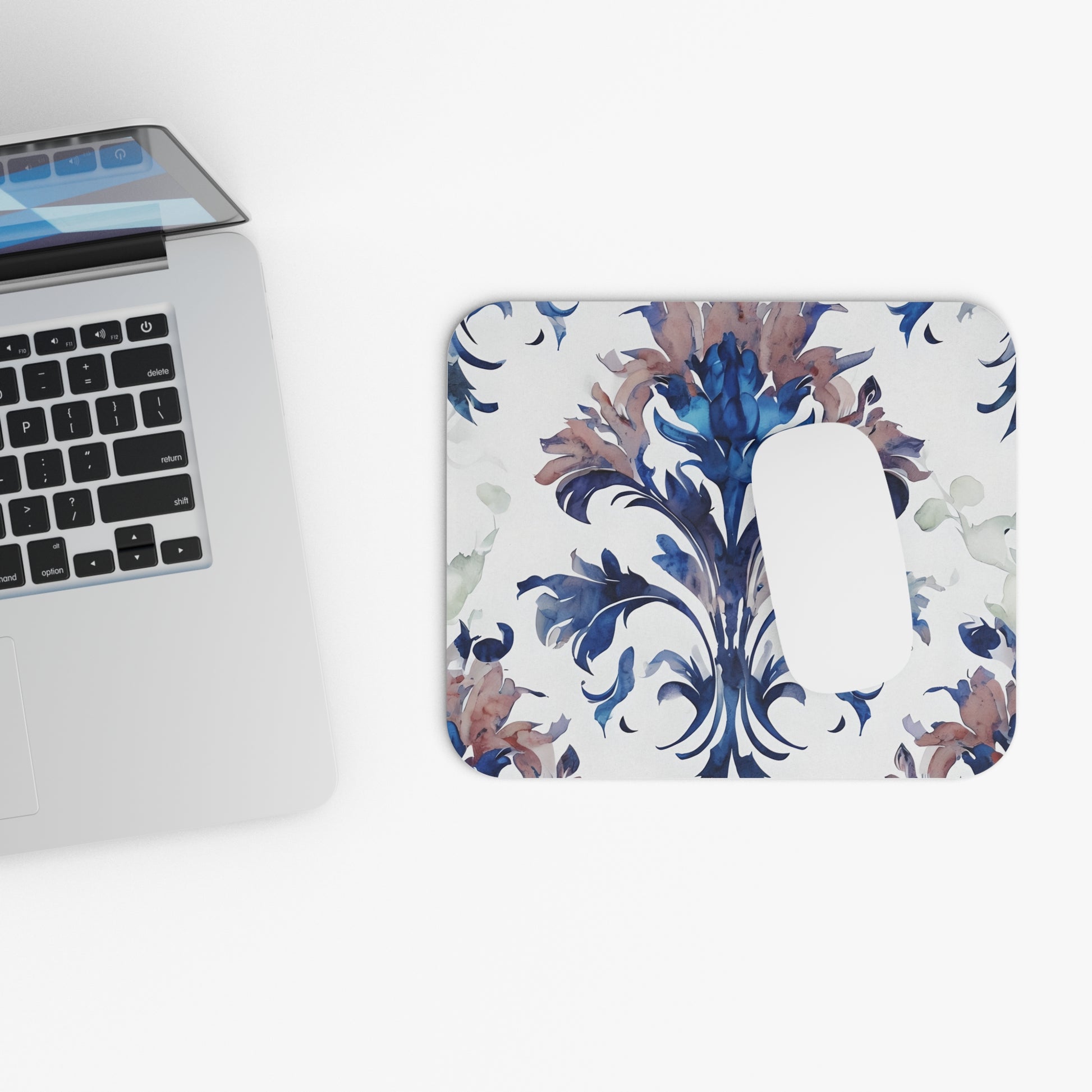 Delft Reverie mouse pad beside laptop displaying Delft-style floral artwork