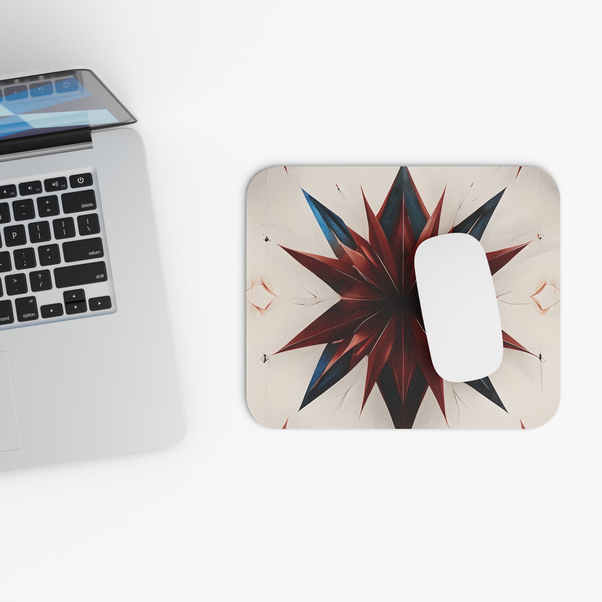 Garnet Starburst mouse pad beside laptop displaying geometric starburst design