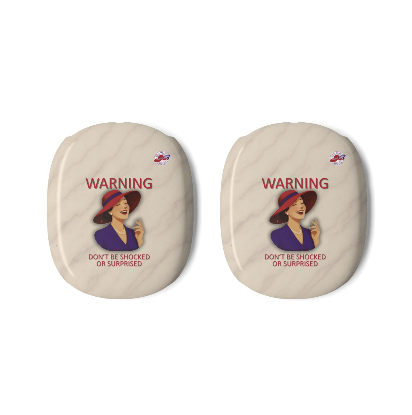 Two oval-shaped beige AirPods Max covers with a vintage warning label featuring a laughing woman in a red hat and the text 'WARNING DON'T BE SHOCKED OR SURPRISED', alongside the Red Hat Society Logo shown on a plain white background.