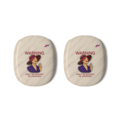 Two oval-shaped beige AirPods Max covers with a vintage warning label featuring a laughing woman in a red hat and the text 'WARNING DON'T BE SHOCKED OR SURPRISED', alongside the Red Hat Society Logo shown on a plain white background.